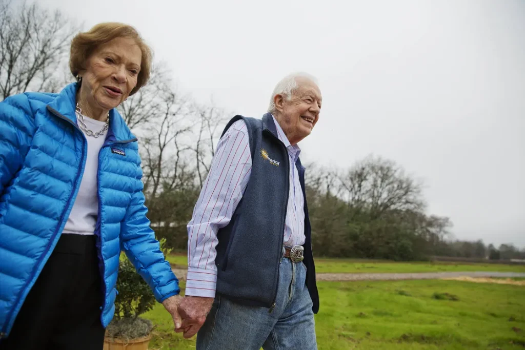 Rosalynn Carter and former President Jimmy Carter walk on farmland he owns in their hometown, Plains, Ga., on Feb. 8, 2017.David Goldman / AP file